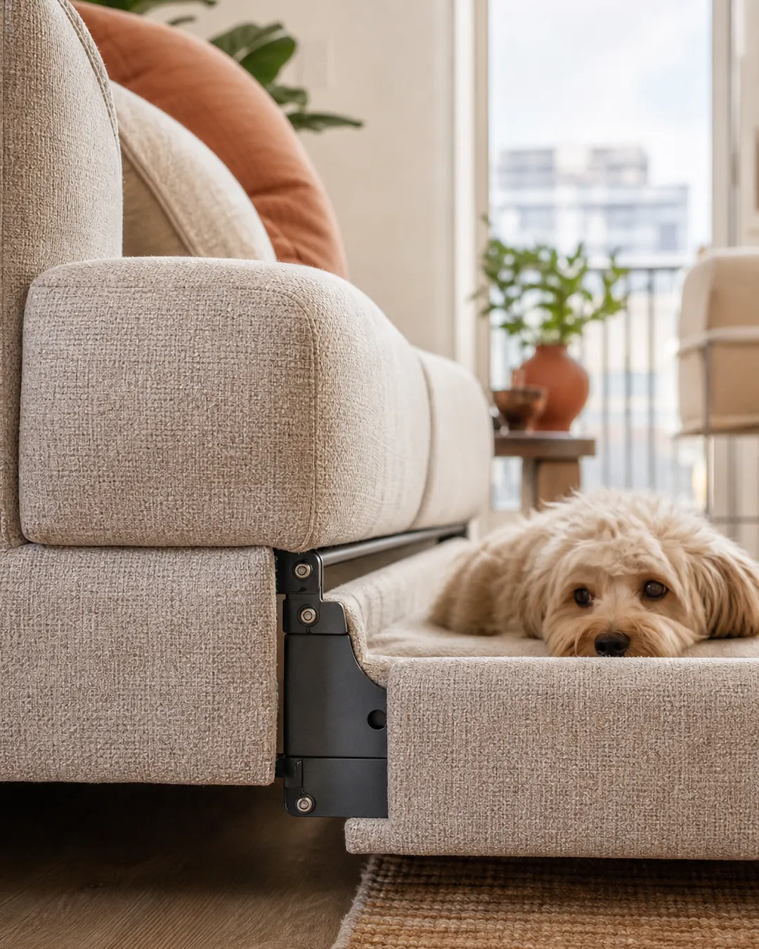 Neutral dog bed matching the fabric of the sofa standing behind it